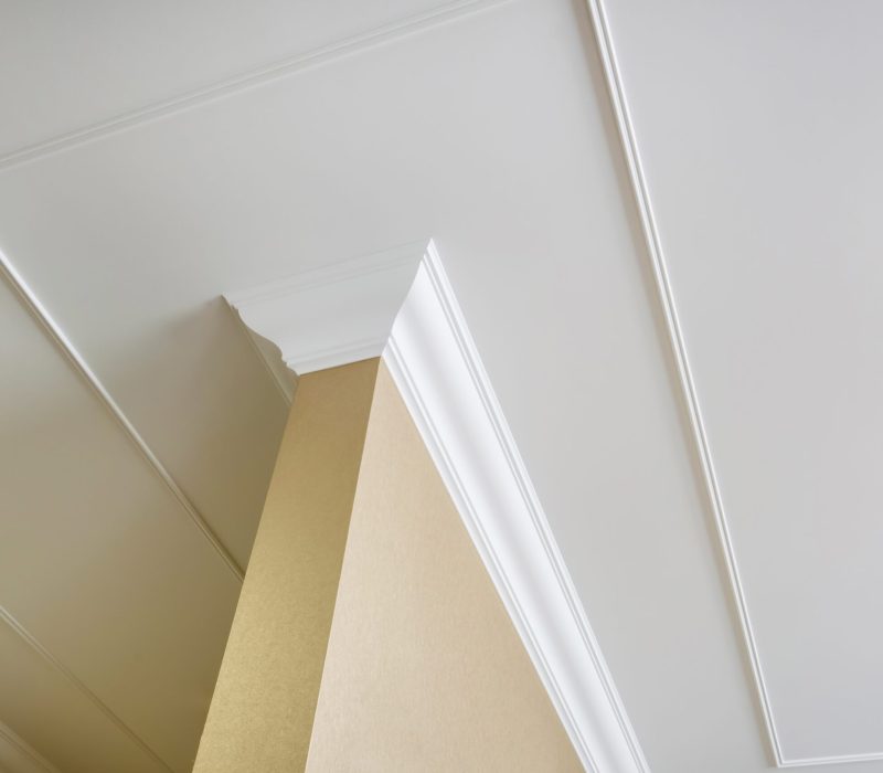 Detail of corner ceiling and walls with intricate crown moulding. Interior construction and renovation concept.