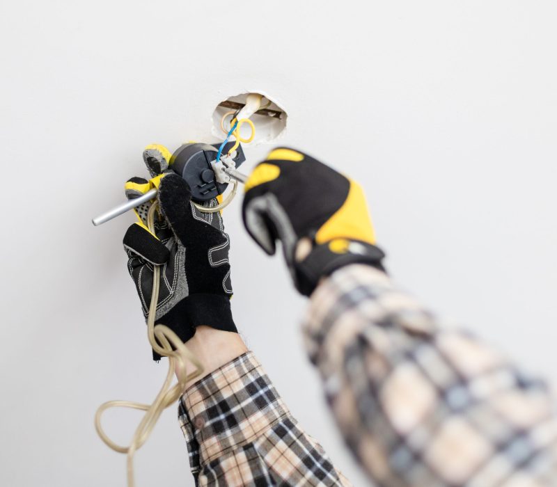 electrician repairing suspend of ceiling lamp at home