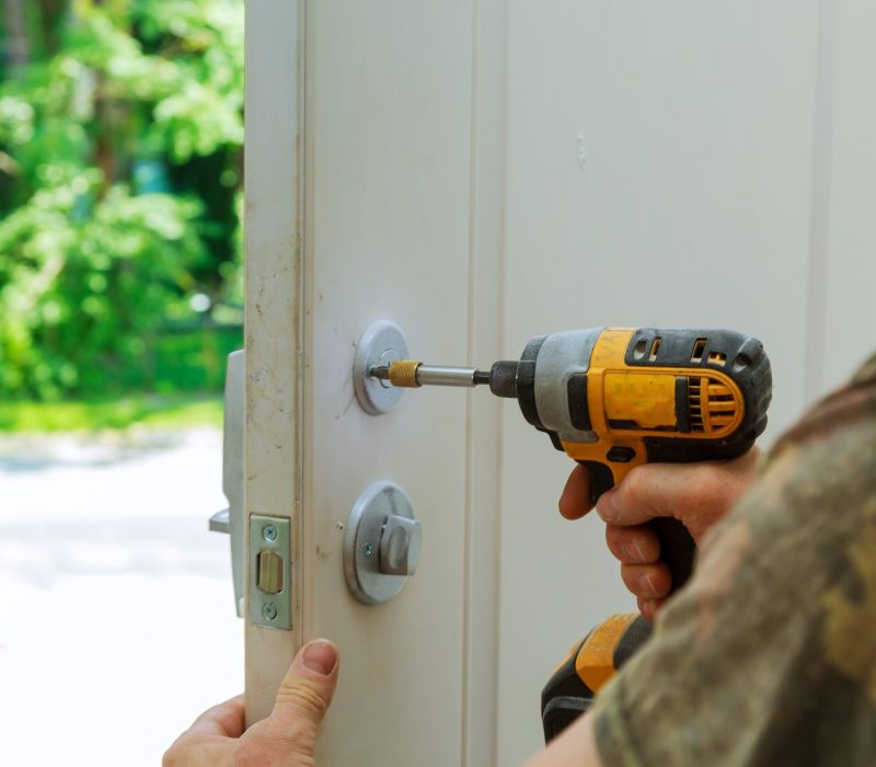 Installation locked interior door knobs, close-up woodworker hands install lock. installation of a lock at the door